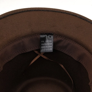 Detail view of cotton blend material label inside dark brown wool fedora cowboy hat