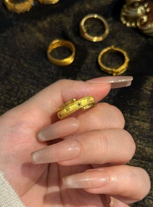 Close-up of vintage gold ring featuring celestial star and sun motifs with zircon