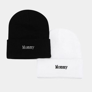 Matching black and white knitted beanies with Mommy embroidery for couples and parents