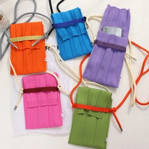 Detailed top view of colorful knitted pleated phone bags in orange, blue, and purple tones