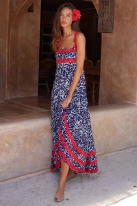 Detail of blue leopard print dress showing red scallop trim and side slit texture