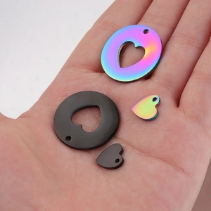 Macro view of four hollow heart-shaped stainless steel pendants in rainbow and black finish