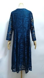 Detail of elegant dark blue lace dress featuring intricate floral hollow patterns and texture