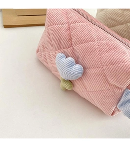 Detail of pink corduroy makeup bag with quilted pattern and 3D tulip floral design