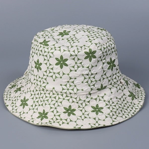 Détail du chapeau de soleil crème avec texture de tissu jacquard à fleurs vertes