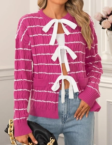Detail of rose purple knit cardigan featuring ribbed texture and white ribbon bow ties
