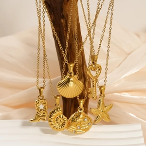 Golden shell and starfish pendant necklaces on a wooden branch with silk background
