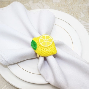 Detailed macro view of a vibrant yellow lemon napkin ring on a white table setting