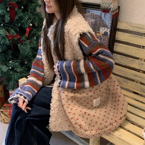 Detail of plush beige tote bag with red hearts and woven label in winter setting
