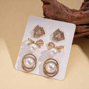 Detailed view of three pairs of rhinestone earrings with pearls and bowknot designs