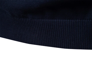 Gros plan détaillé de l'ourlet côtelé bleu foncé sur un pull en tricot pour homme