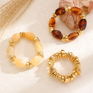 Detail of beaded bracelet set with brown resin, marble texture, and gold irregular beads