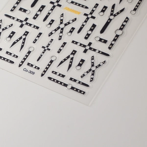 Macro detail of 5D embossed punk nail art stickers with silver crosses and belt motifs