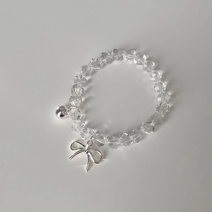 Kristallperlenarmband mit silbernem Schleifenanhänger auf minimalistischem Grund