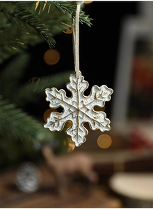 Macro view of white resin snowflake ornament with elegant gold painted edge detailing