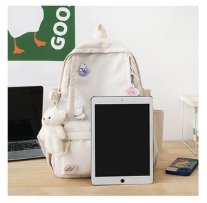 Zaino crema minimalista con tasche, ciondoli e riferimento dimensionale per tablet da 11 pollici