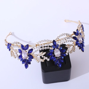 Close-up of golden bridal crown with deep blue crystals and floral vine details
