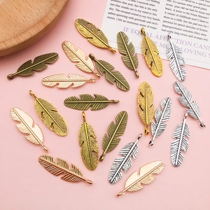 Macro shot of feather leaf alloy pendants in gold, silver, bronze and rose gold finishes