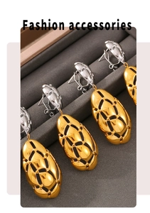 Detail view of oval drop earrings with gold and silver tones in a jewelry organizer