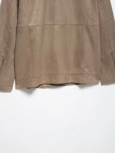 Detail view of khaki suede jacket showing hem stitching and metal zipper cuffs
