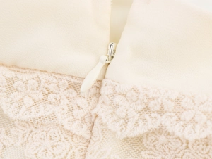 Détail de la fermeture éclair invisible et dentelle florale sur robe en mousseline