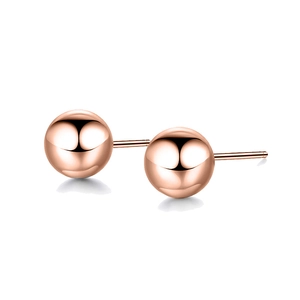 Detailed view of polished rose gold ball stud earrings with mirror finish surface