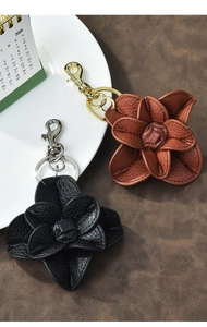 Detail of leather camellia flower keychain with premium lychee grain texture and metal ring