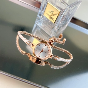 Elegant rose gold women's bracelet watch with white enamel accents and adjustable strap