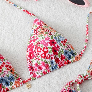 Detailed view of floral bikini top with triangle cups and delicate gold flower pendant