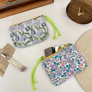 Detail of floral makeup pouches with vibrant green rope zipper pulls and soft lining