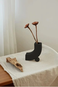 Detailansicht der L-förmigen matt-schwarzen Keramikvase mit Trockenblumen im Zen-Stil