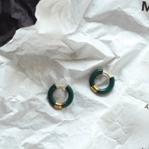 Detailed macro view of dark green enamel hoop earrings with 18K gold-plated accents
