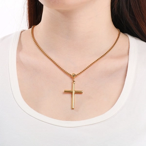 Polished gold stainless steel cross pendant necklace with box chain on a model