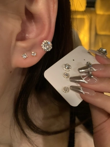 Detail view of gold-plated round zircon stud earrings worn to show elegant daily fit
