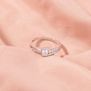 Macro shot of silver ring with round-cut cubic zirconia in a bypass setting