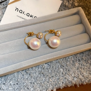 Detail view of pearl and pavé zirconia double-bead earrings on gray velvet display
