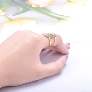 Detail of adjustable golden textured ring with dual-line band on female hand