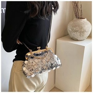 Detail of silver sequin evening bag with gold metal frame and round clasp closure