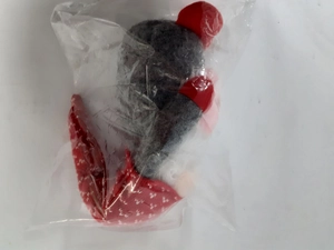Gnome doll in a transparent protective bag showing red and grey felt materials