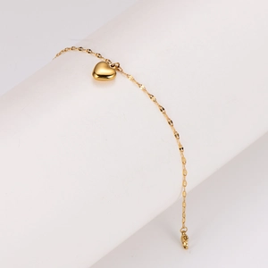 Elegant gold heart pendant bracelet displayed on a white stand with a minimalist thin chain