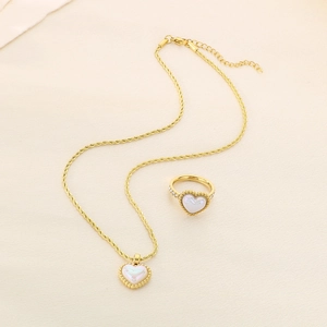 Detail of heart shell necklace and ring set with twisted chain in golden finish