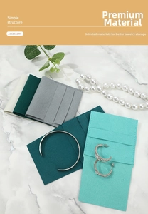 Detail of microfiber jewelry pouch with multi-slot organizer on white marble background