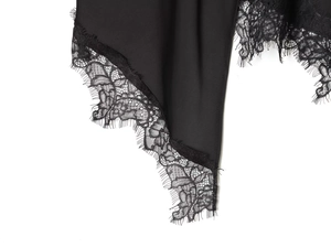 Detailed close-up of delicate black eyelash lace trim and irregular hemline stitching