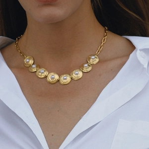 Elegant gold titanium steel necklace featuring white pearl inlays on circular charms