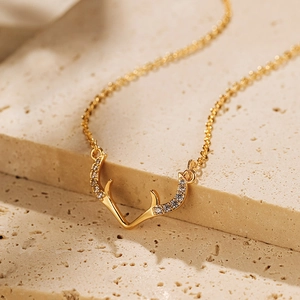 Elegante collana placcata oro con pendente a corno di cervo e zirconi su pietra beige