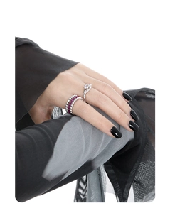 Close-up of S925 sterling silver rings set with red and clear gems on black mesh