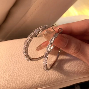 Silver hoop earrings with sparkling baguette-cut cubic zirconia in a minimalist style