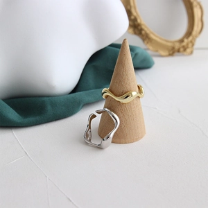 Minimalist irregular wave-shaped rings in gold and silver finish for women on display