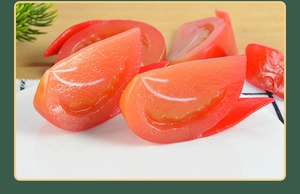 Close-up of realistic faux tomato slices with detailed seeds on a white ceramic plate