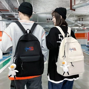 Canvas street-style backpacks in black and cream featuring China embroidery and plush charm
